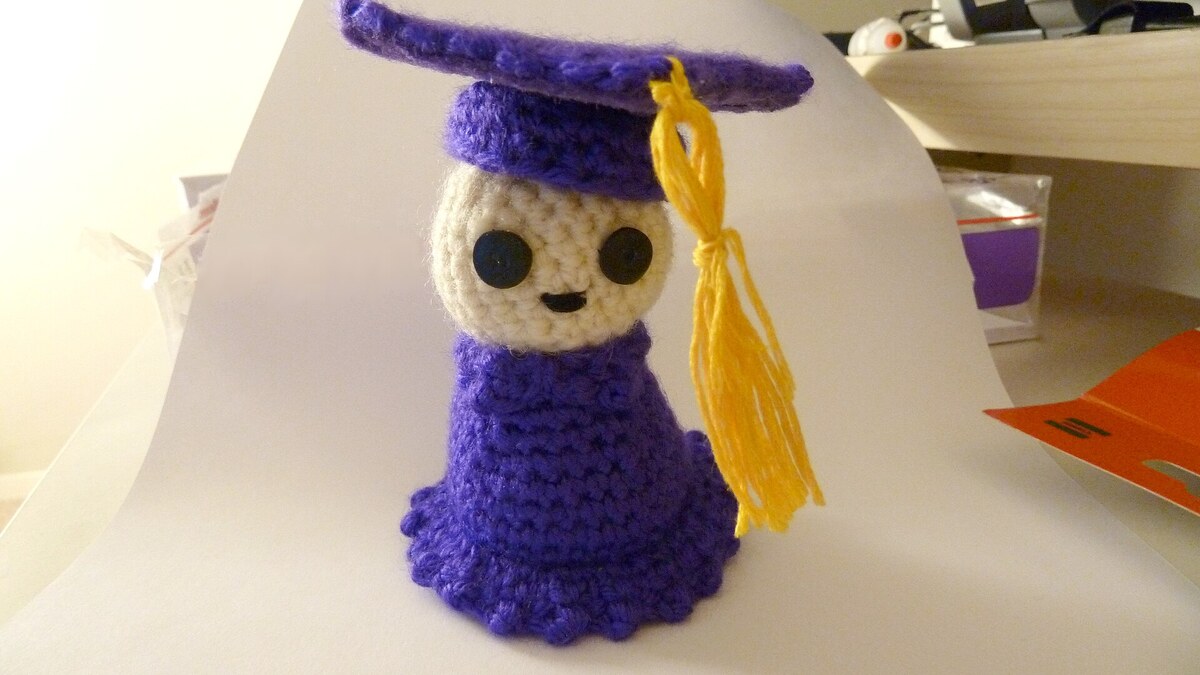 Personnage amigurumi violet au crochet photographié sur fond clair