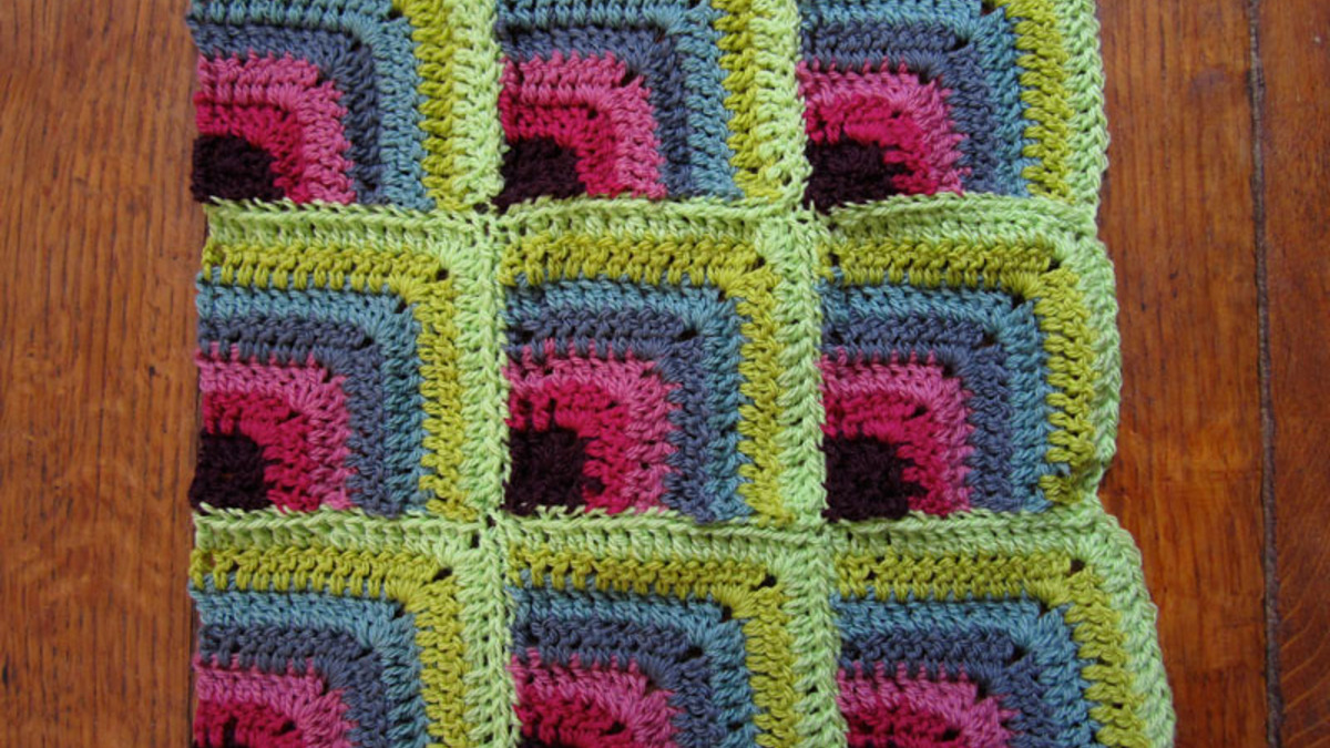 Ouvrage au crochet coloré posé sur une table en bois, pour choisir un modèle à imprimer