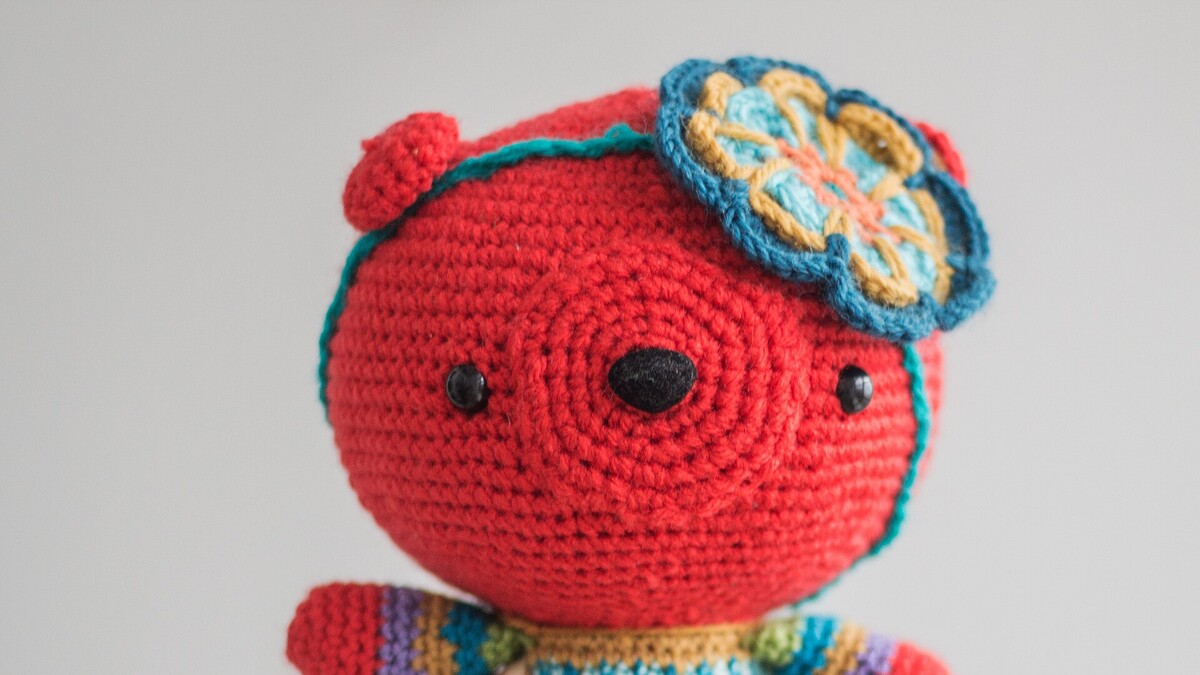 Peluche amigurumi rouge au crochet tenue à la main