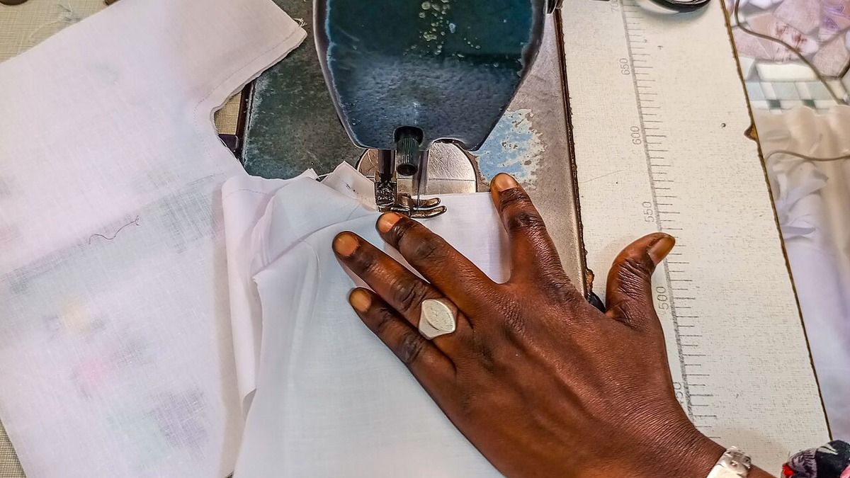 Machine à coudre, tissu blanc et ciseaux pendant une couture