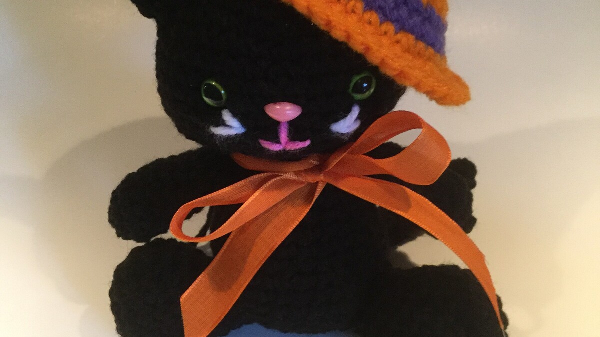 Yeux de sécurité noirs posés sur un chat amigurumi au crochet