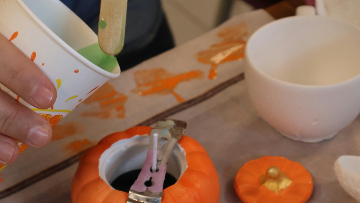 Atelier créatif d’Halloween avec mini-citrouilles, peinture orange et pinceau
