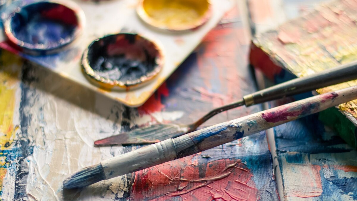 Pinceaux et palette de peinture colorée sur une surface de travail