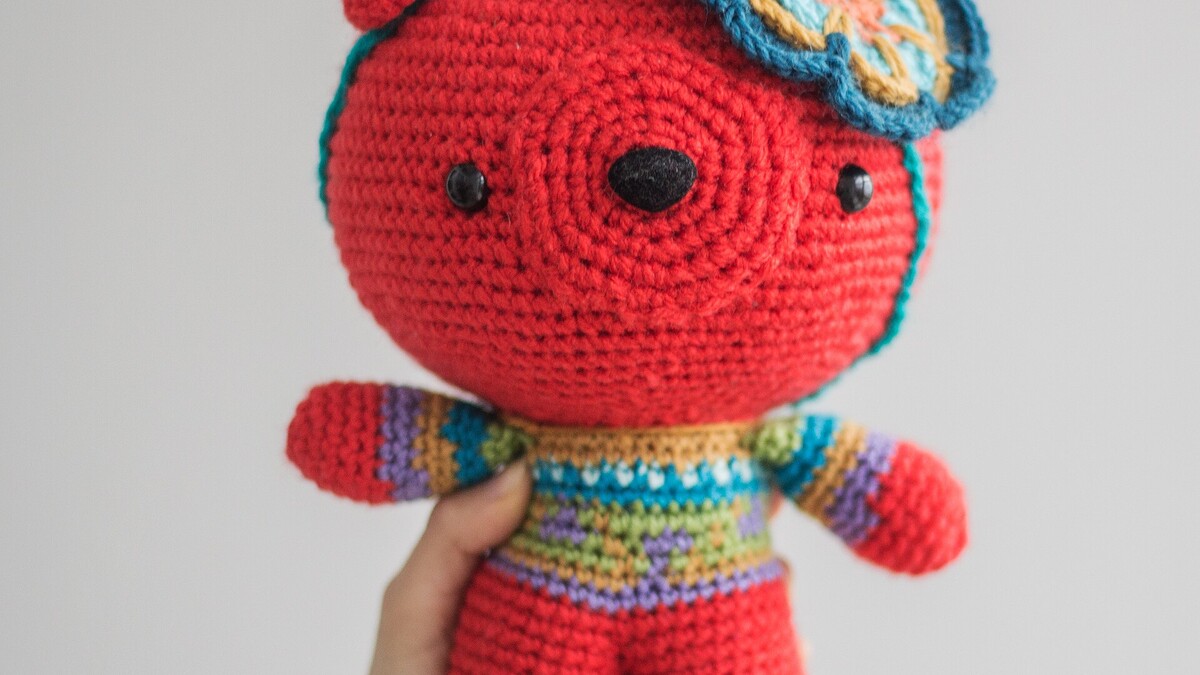 Petit ours amigurumi rouge avec de grands yeux noirs